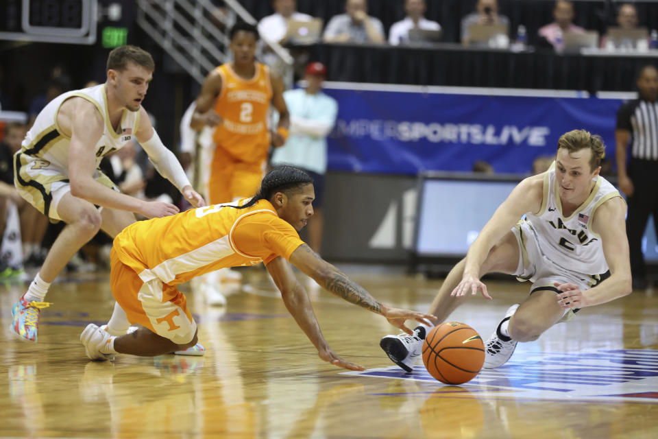 Tennessee guard Zakai Zeigler, left, and Purdue guard Fletcher Loyer (2) dive for a loose ball during the second half of an NCAA college basketball game, Tuesday, Nov. 21, 2023, in Honolulu. (AP Photo/Marco Garcia)