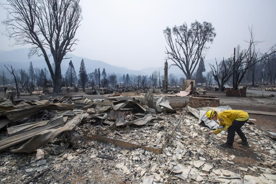 Amanda Peri, an inspector with Cal Fire Shasta Trinity Unit, searches through debris