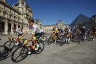 Slovenia's Tadej Pogacar, wearing the overall leader's yellow jersey, rides in front of The Louvre Museum with his UAE Team Emirates teammates during the twenty-first and last stage of the Tour de France cycling race over 108.4 kilometers (67.4 miles) with start in Chatou and finish on the Champs Elysees in Paris, France, Sunday, July 18, 2021. (Yoan Valat/Pool Photo via AP)