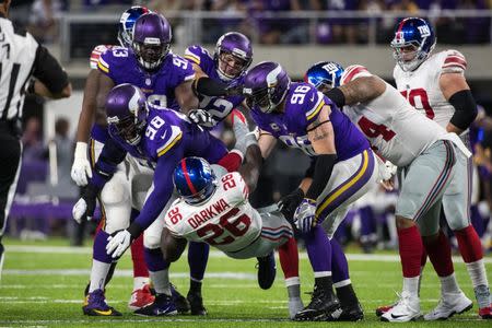 Oct 3, 2016; Minneapolis, MN, USA; New York Giants running back Orleans Darkwa (26) is tackled by Minnesota Vikings defensive tackle Linval Joseph (98) and defensive end Brian Robison (96) during the first quarter at U.S. Bank Stadium. Mandatory Credit: Brace Hemmelgarn-USA TODAY Sports