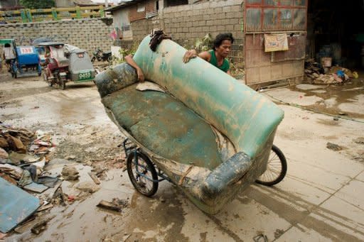 A man uses a bicycle to transport a sofa chair in Tomana slum, Marikina city in the suburbs of Manila on August 11. Deadly floods, power blackouts and traffic gridlock -- many of Asia's biggest cities are buckling under the strain of rapid economic development, extreme weather and an exodus from the countryside