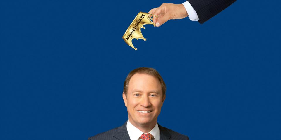 A man in a business suit dangles a gold crown emblazoned with the Morgan Stanley logo over Ted Pick's head.