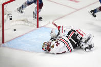 Chicago Blackhawks goaltender Petr Mrazek lies on the ice as the puck sits in goal on a score by Colorado Avalanche center Andrew Cogliano during the first period of an NHL hockey game Wednesday, Oct. 12, 2022, in Denver. (AP Photo/Jack Dempsey)