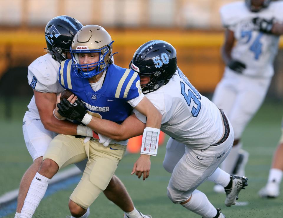 Schroeder quarterback Andrew Hilfiker is sacked by Eastridge’s Ronald Dietz and Ian Schneeberger.