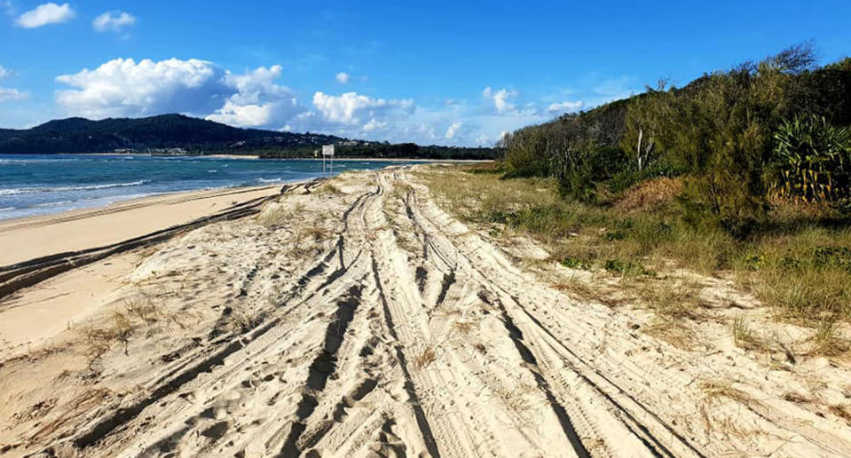 Tyre tracks seen across the sand at Noosa North Shore Beach Campground. A furious resident has hit out blaming tourists for leaving garbage behind.