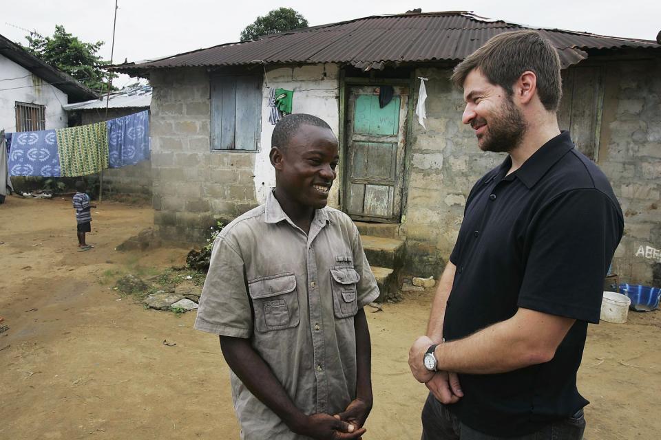 Joseph Duo (L), 28, a former Liberian government soldier, talks with photographer Chris Hondros at his home October 5, 2005 in Monrovia, Liberia. (Photo: Getty Images)