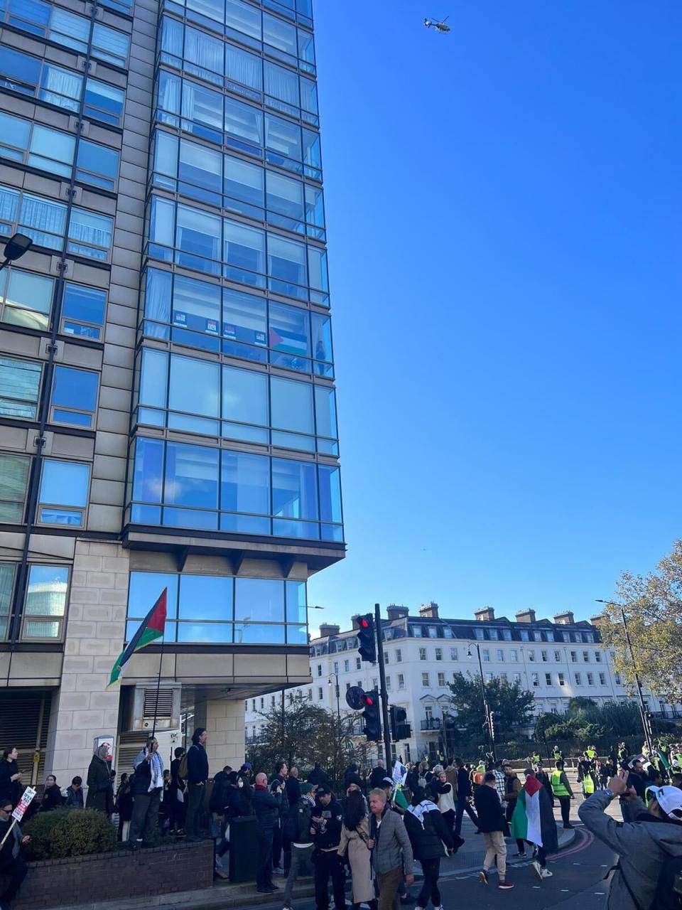 One man sits above the chaos championing a Palestine flag from his window (Provided)