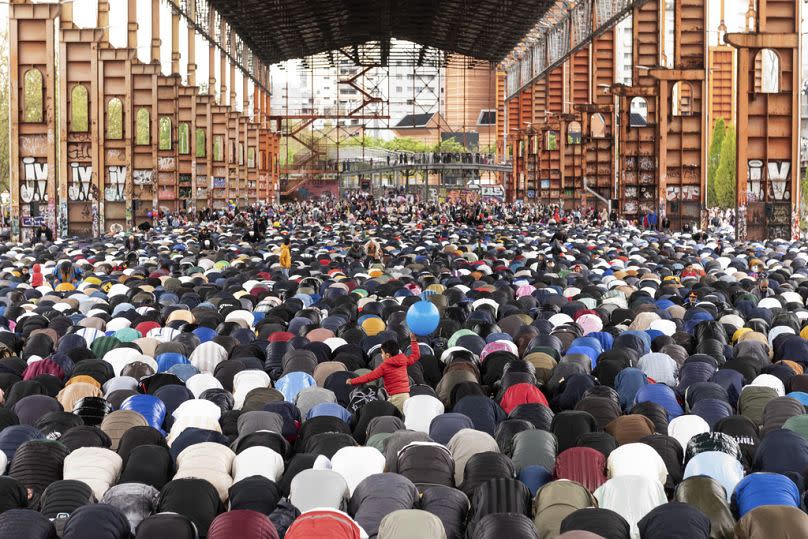 A young boy plays with a balloon during Eid Al-Fitr prayers marking the end of the Islamic holy month of Ramadan, at Parco Dora, in Turin, Italy, Wednesday, April 10, 2024.