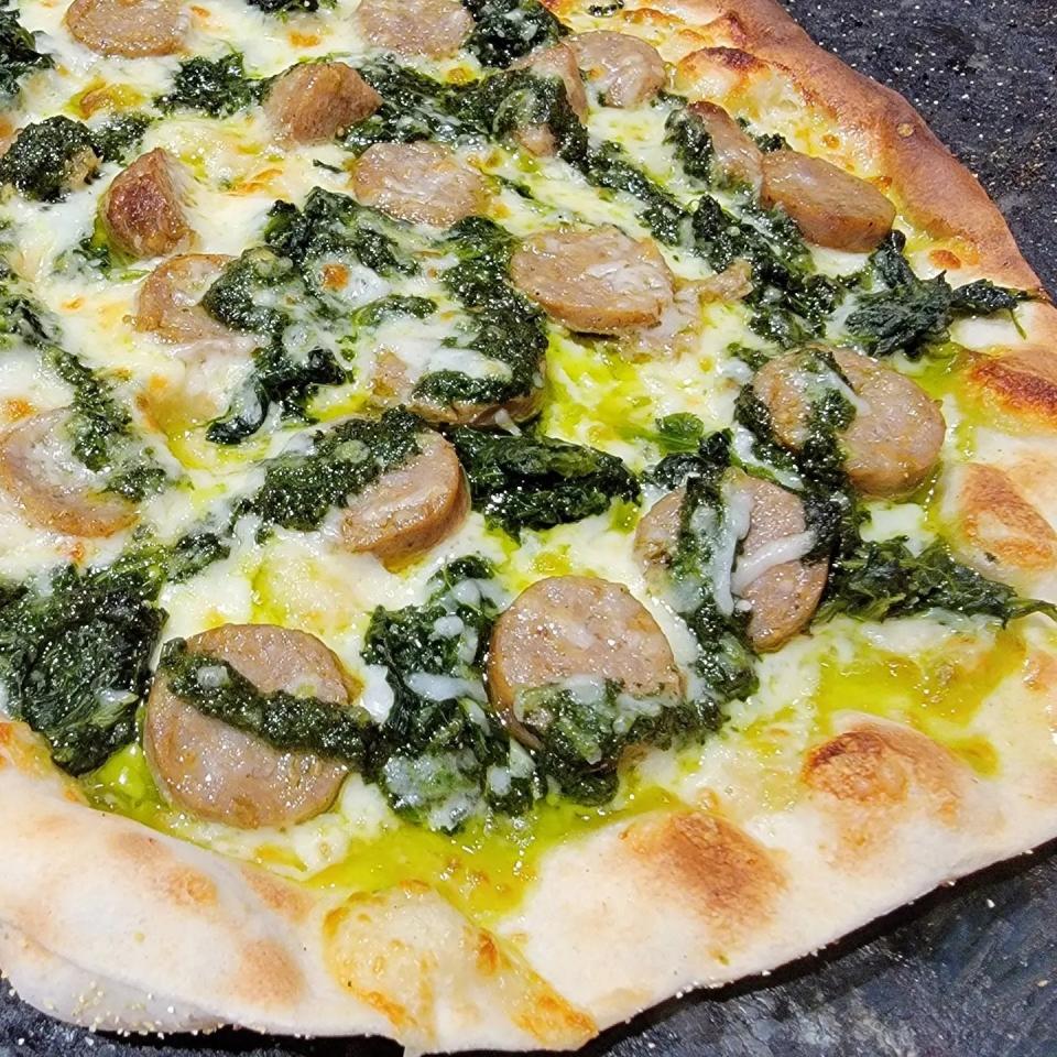 Wood-fired pizzas, like this one with spinach and sausage, are favorites at Ossorio Bakery & Cafe in Cocoa Village.