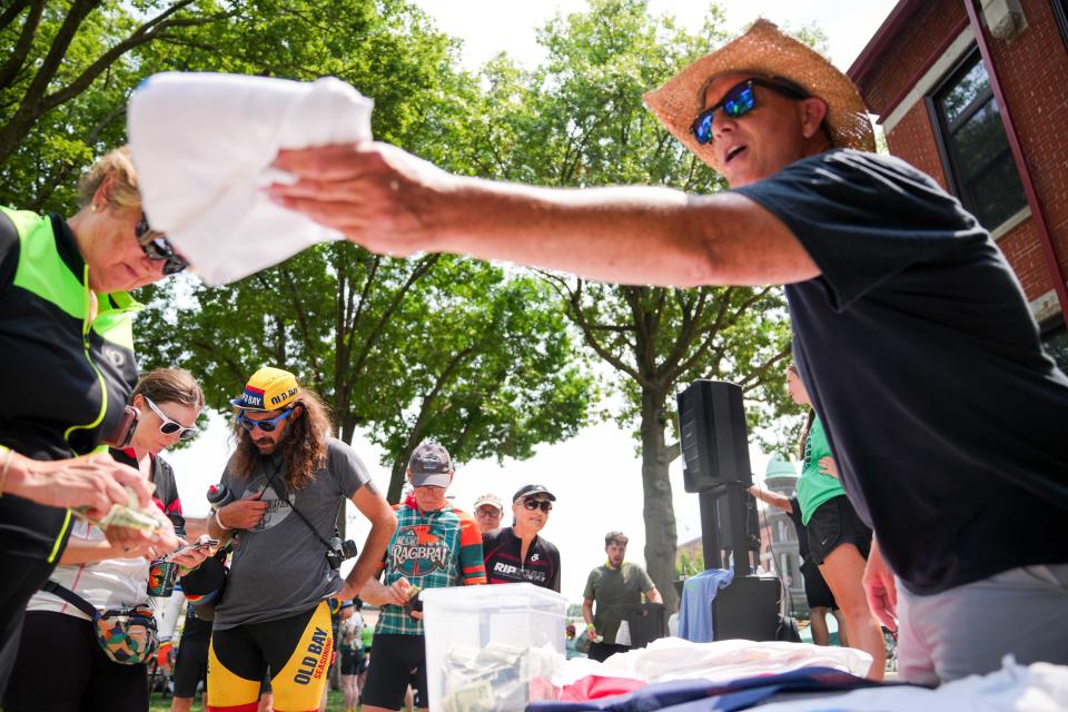 RAGBRAI riders receive a free T-shirt after making a donation to Greenfield's tornado recovery efforts on Tuesday, July 23, 2024, in Greenfield, IA.
