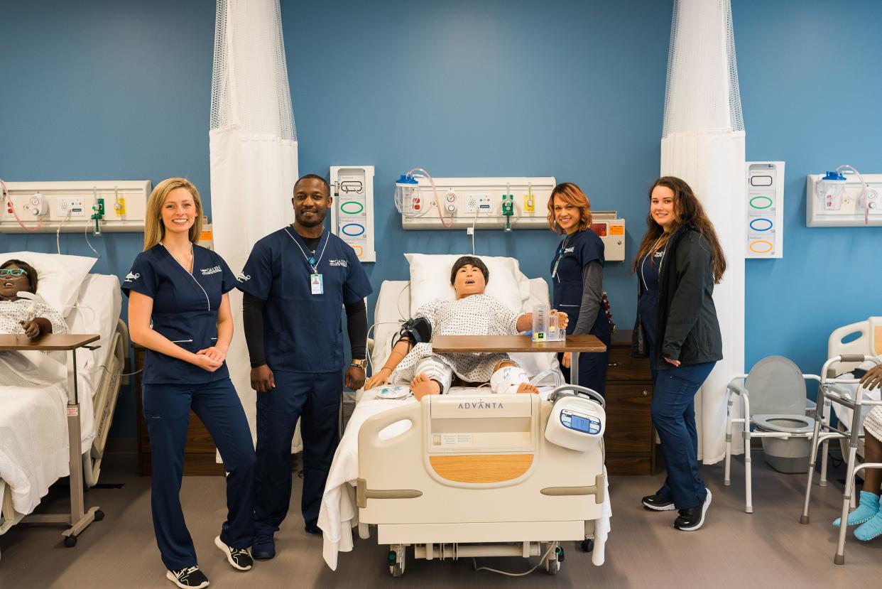 Health care students flank a practice station at Galen College of Nursing's new campus in Asheville.