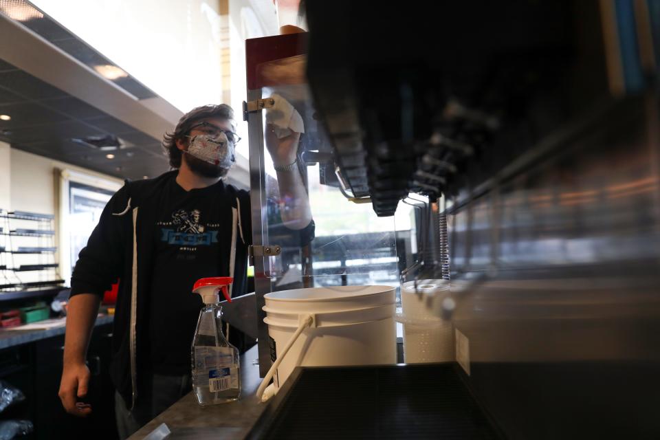 Nathaniel Dunaway wipes down the popcorn machine at Salem Cinema in October 2020 ahead of the theater's reopening after being closed for seven months during the pandemic.