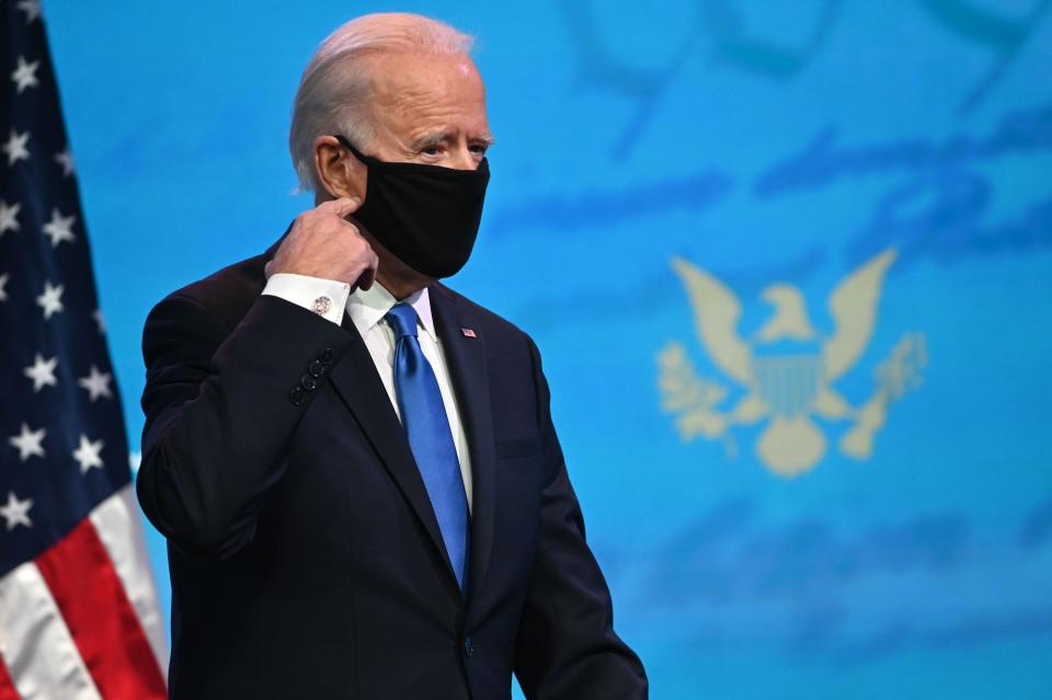 US President-elect Joe Biden removes his facemask as he arrives to deliver remarks on the Electoral college certification at the Queen Theatre in Wilmington, Delaware on December 14, 2020. (Photo by ROBERTO SCHMIDT / AFP) (Photo by ROBERTO SCHMIDT/AFP via Getty Images)