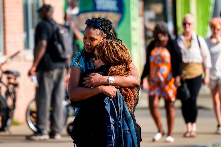 People embrace outside the scene of a shooting at a supermarket in Buffalo, N.Y., on May 15, 2022.