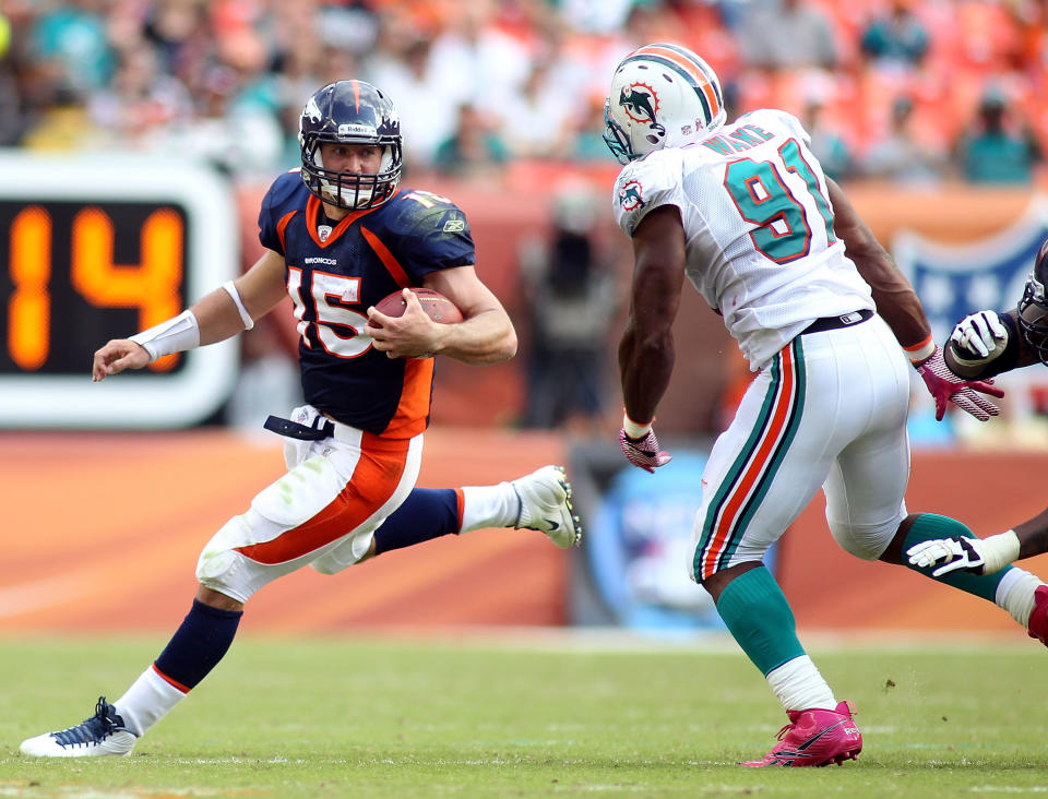 MIAMI GARDENS, FL - OCTOBER 23: Quarterback Tim Teebow #15 of the Denver Broncos rolls out against Cameron Wake #91 of the Miami Dolphins to end the game to overtime at Sun Life Stadium on October 23, 2011 in Miami Gardens, Florida. Denver defeated Miami 18-15. (Photo by Marc Serota/Getty Images)