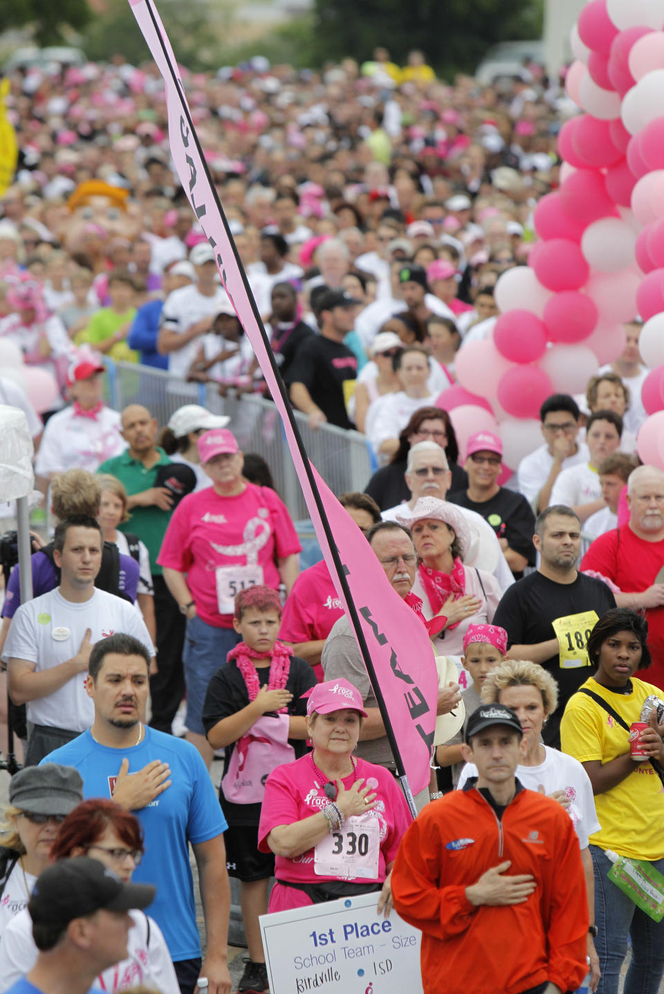 CORRECTS TO REMOVE REFERENCE TO NUMBER OF YEARS AND RACES, TIGHTEN 2ND HALF OF CAPTION - In this April 14, 2012, photo walkers and runners stop for the Star Spangled Banner before the start of the Cure in Fort Worth, Texas. Organizers of Race for the Cure events across the country have reported drops in participation following a controversy involving Planned Parenthood. In Fort Worth, the participation declined by 23 percent. (AP Photo/Star-Telegram, Joyce Marshall) MAGS OUT