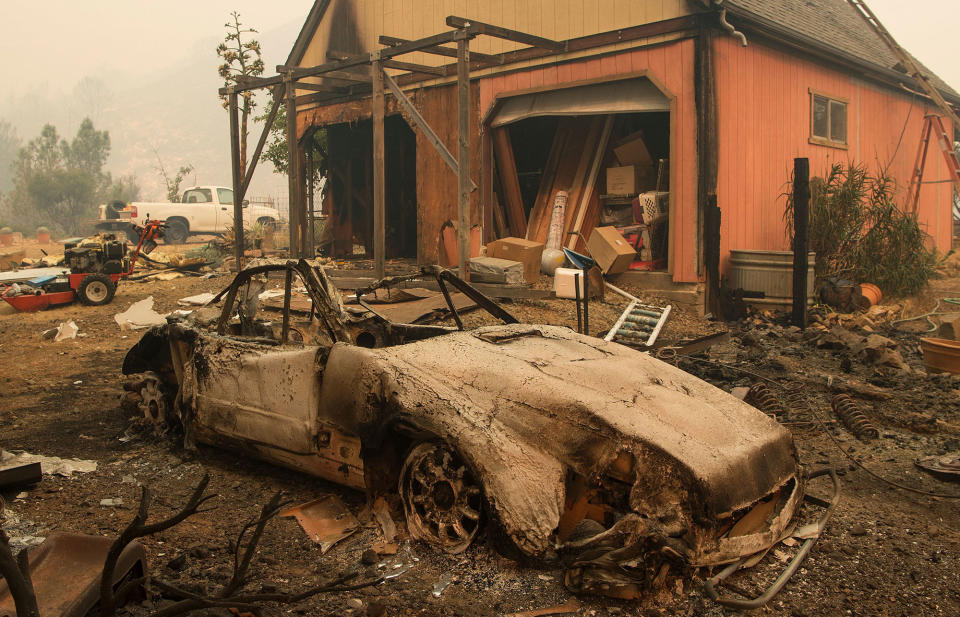 <p>A burned out Porsche is seen near a partially burned home in the Santa Cruz Mountains near Loma Prieta, California on September 27, 2016. The Loma Prieta Fire has charred more than 1000 acres and burned multiple structures in the area. (Josh Edelson/AFP/Getty Images) </p>