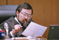 FILE - Judge Lance Ito views evidence with a magnifying glass during O.J. Simpson's double-murder trial, Aug. 25, 1995, in Los Angeles. Simpson, the decorated football superstar and Hollywood actor who was acquitted of charges he killed his former wife and her friend but later found liable in a separate civil trial, has died. He was 76. (AP Photo/Pool/Mark J. Terrill, File)