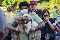 A resident carries his pets as he evacuates from a flooded area after heavy rain in Porto Alegre, Rio Grande do Sul state, Brazil, Tuesday, May 7, 2024. (AP Photo/Carlos Macedo)