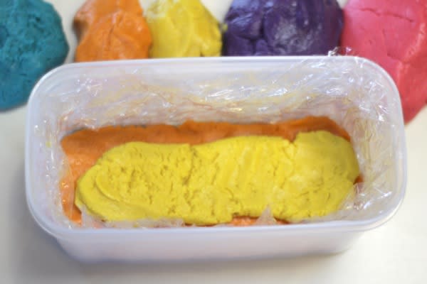 Using a rectangular plastic container lined with plastic wrap, the dough is layered and spread on top of each other. The black dough is placed on the bottom for the hooves of the burro.