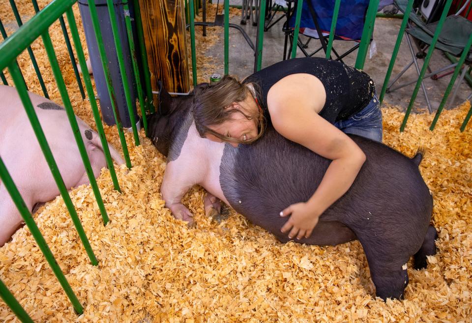 Grace Finneman, 17, gives her hog named Pooh a hug in the animal barns during the Lane County Fair Wednesday, July 20, 2022.