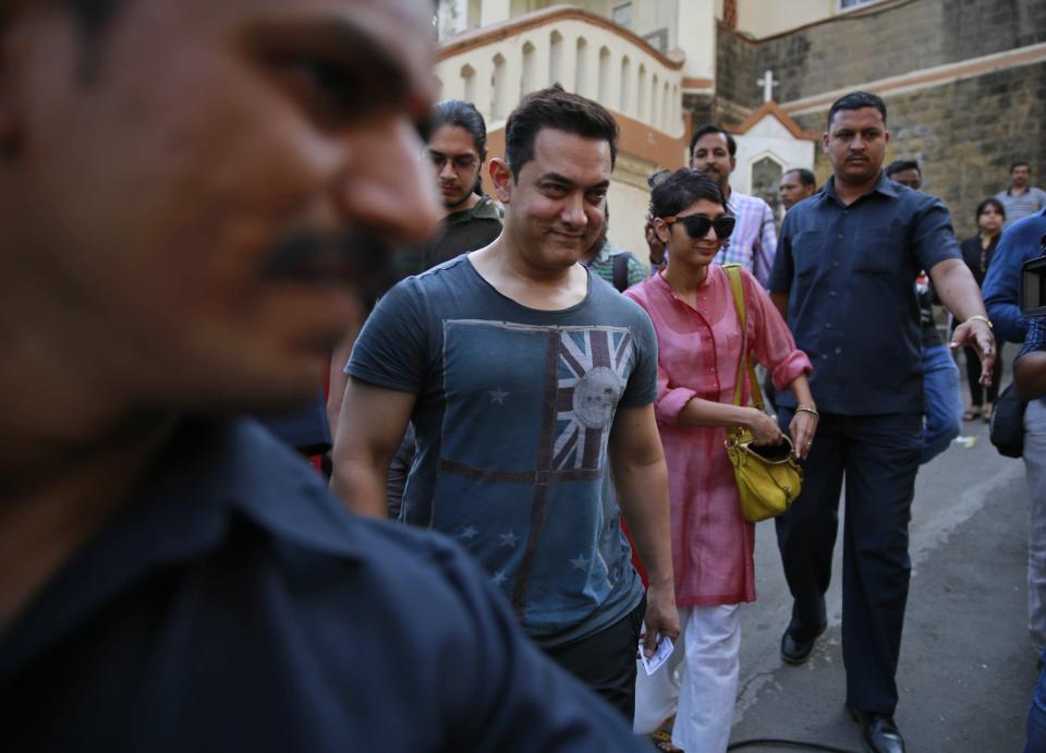 Bollywood actor Aamir Khan, center, arrives with his wife Kiran Rao to cast their vote during the sixth phase of polling of the Indian parliamentary elections in Mumbai, India, Thursday, April 24, 2014.The multiphase voting across the country runs until May 12, with results for the 543-seat lower house of parliament expected on May 16. (AP Photo/Rafiq Maqbool)