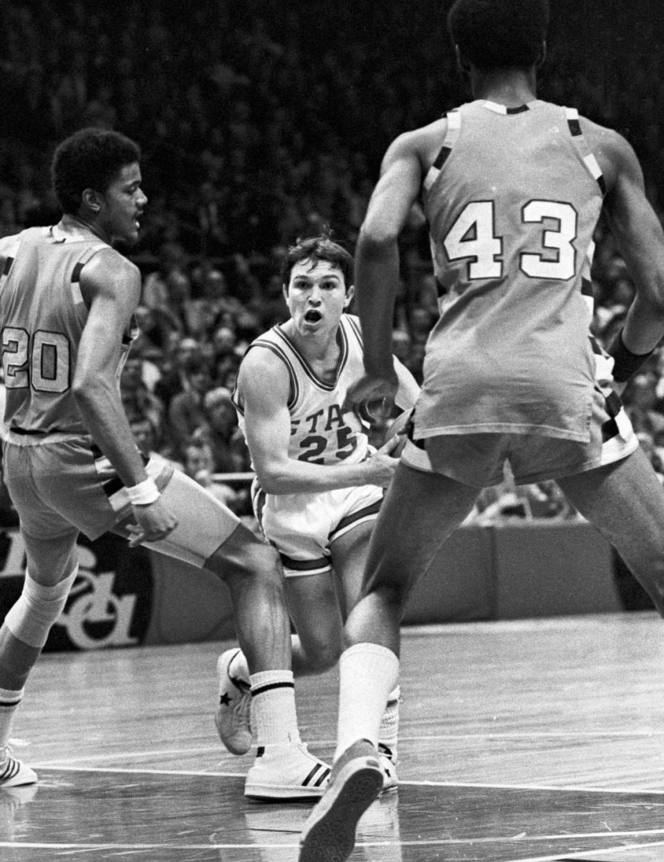 NC State point guard Monte Towe drives against Marquette defenders during the 1974 National Championship game.