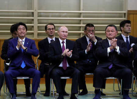 Russian President Vladimir Putin (C), Japanese Prime Minister Shinzo Abe (L) and Vice Chairman of the All Japan Judo Federation Yasuhiro Yamashita (R) look at a performance of ancient custom judo as they visit the Kodokan Judo Institute, the headquarters of the worldwide judo community, in Tokyo, Japan, December 16, 2016. Sputnik/Michael Klimentyev/Kremlin via REUTERS