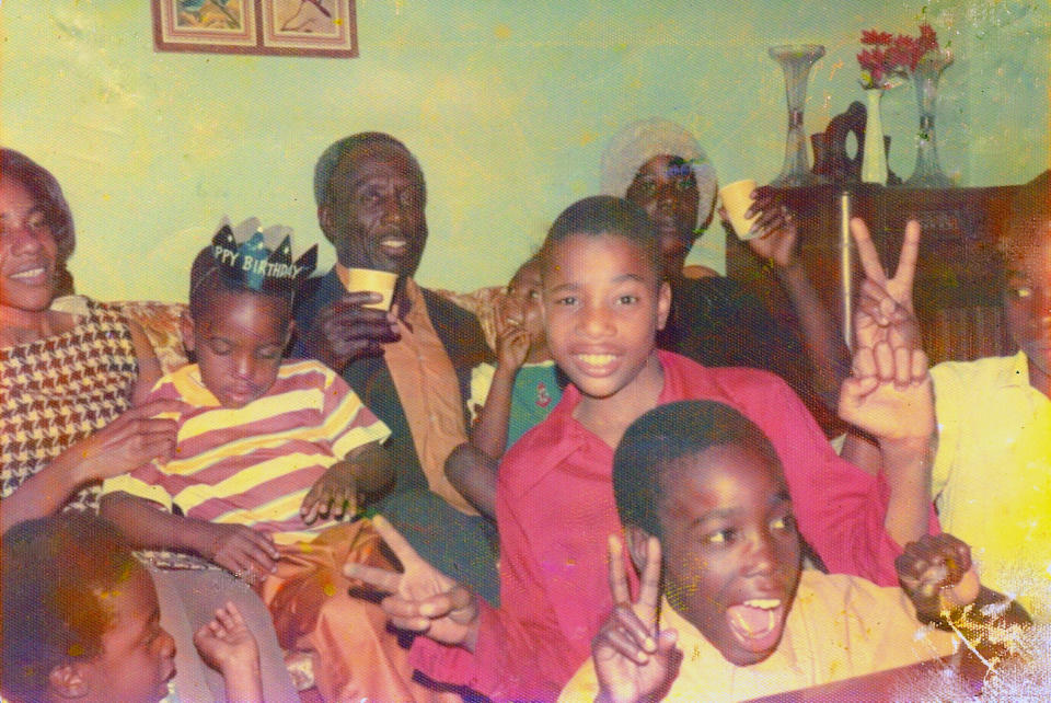 The Warnock family, pictured in 1974, celebrates the birthday of cousin Michael, seated on Verlene Warnock's lap. Future Senator Warnock, bottom left corner, attempts to imitate his older brother's pose while his father Jonathan, seated center, smiles at the camera<span class="copyright">Courtesy of Senator Raphael Warnock</span>