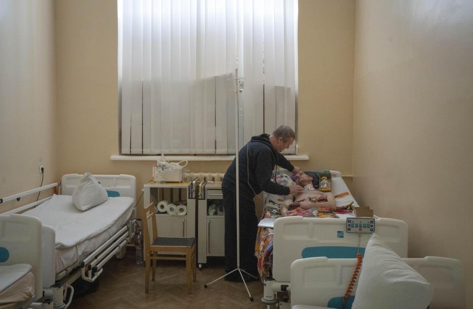 Serhii Shumei, 64, talks to his son Vitalii, 34, a Ukrainian officer heavily wounded in a battle with Russian forces, in a city hospital in Chernihiv, Ukraine, Wednesday, Jan. 11, 2023. Vitalii, a long-range anti-aircraft missile commander, was wounded in the Donbas region of eastern Ukraine that has become synonymous with horrific losses in ongoing fighting for both Ukraine and Russia. (AP Photo/Efrem Lukatsky)