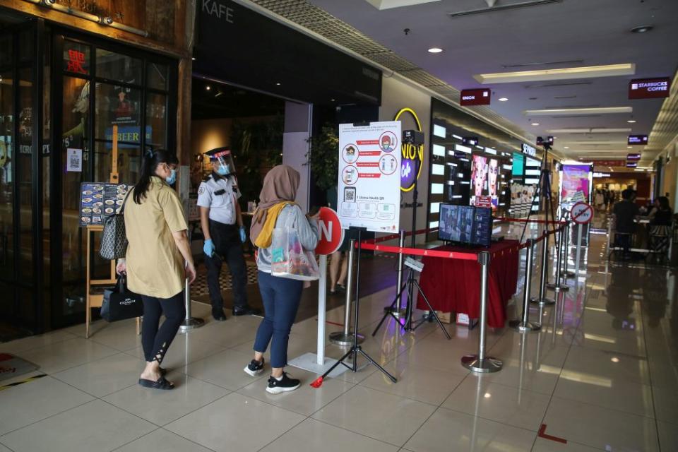 A security personnel monitors thermal scanners as patrons enter the 1Utama shopping mall in Petaling Jaya May 28, 2020. — Picture by Yusof Mat Isa