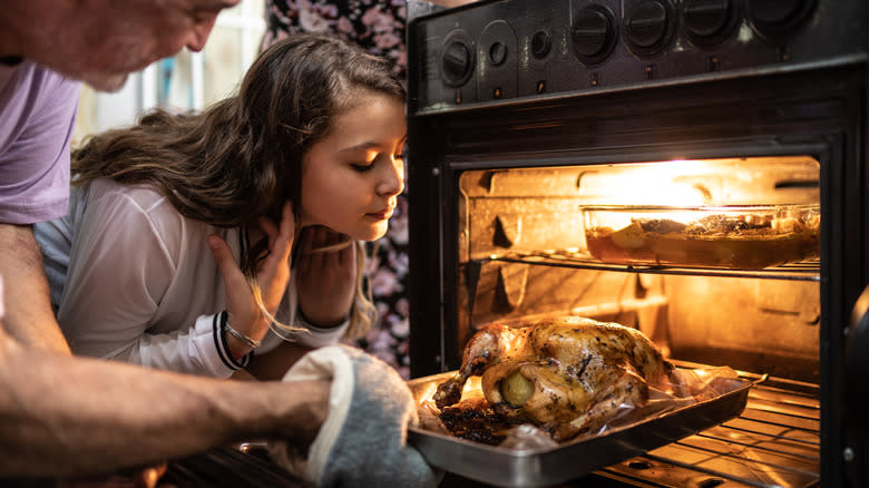 Whole chicken being removed from oven