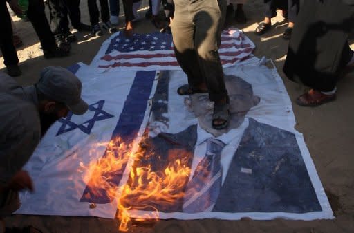 Palestinian Salafists walk on a picture of US President Barack Obama while burning Israeli and US flags during a protest against an amateur film mocking Islam in Rafah in the southern Gaza Strip, September 14. Furious protesters targeted symbols of US influence in cities across the Muslim world on Friday, attacking embassies, schools and restaurants in retaliation for a film that mocks Islam