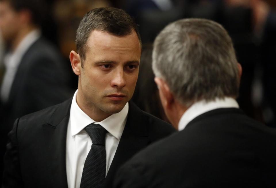 Olympic and Paralympic track star Oscar Pistorius confers with his lawyer Barry Roux on the third day of his trial for the murder of his girlfriend Reeva Steenkamp at the North Gauteng High Court in Pretoria, March 5, 2014. REUTERS/Mike Hutchings (SOUTH AFRICA - Tags: SPORT CRIME LAW ATHLETICS)