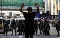 A man tries to stop the fighting between police officers and anti-government protesters in the Central district of Hong Kong