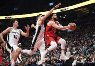 Fred VanVleet, de los Raptors de Toronto, dispara delante de Isaiah Roby (18) y Doug McDermott, de los Spurs de San Antonio, en el encuentro del miércoles 8 de febrero de 2023 (Arlyn McAdorey/The Canadian Press via AP)