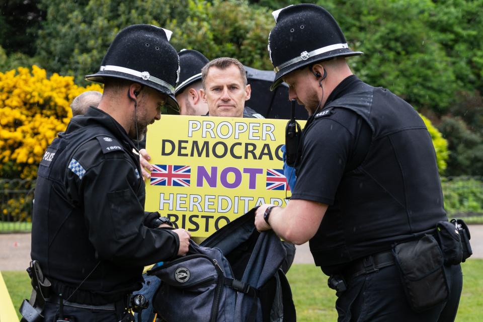 A member of the anti-monarchist group Republic is apprehended by police officers as they stage a protest close to where Britain's King Charles III and Britain's Camilla, Queen Consort will be crowned at Westminster Abbey in central London on May 6, 2023. - The set-piece coronation is the first in Britain in 70 years, and only the second in history to be televised. Charles will be the 40th reigning monarch to be crowned at the central London church since King William I in 1066. Republican opponents who want an elected head of state plan to protest on the day with signs declaring "Not my king". (Photo by Niklas HALLE'N / AFP) (Photo by NIKLAS HALLE'N/AFP via Getty Images)