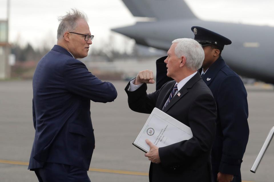 Vice President Mike Pence greets Washington Gov. Jay Inslee, left, as Pence arrives, Thursday, March 5, 2020 at Joint Base Lewis-McChord in Washington state.