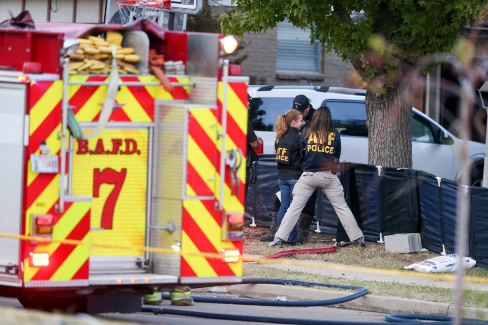 Broken Arrow police and fire officials investigate the scene of a house fire with multiple fatalities on Thursday.