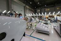 A worker inspects a plane part made at the Strata Manufacturing facility, in Al Ain