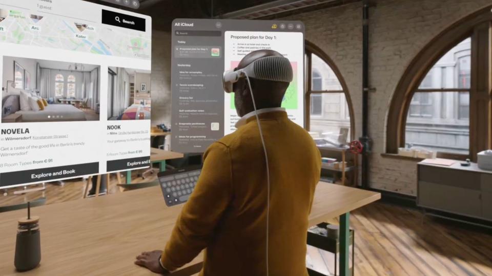 Άνθρωπος που χρησιμοποιεί το Apple Vision Pro σε ένα γραφείο.