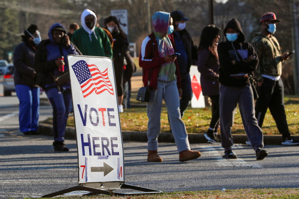 A sign is seen as voters line up for the U.S. Senate run-off election, at a polling location in Marietta, Georgia, U.S., January 5, 2021. REUTERS/Mike Segar