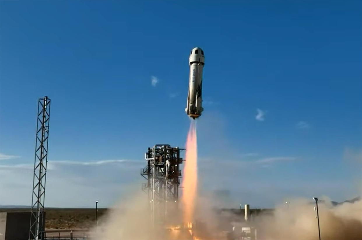  A white rocket launches into a blue sky. 