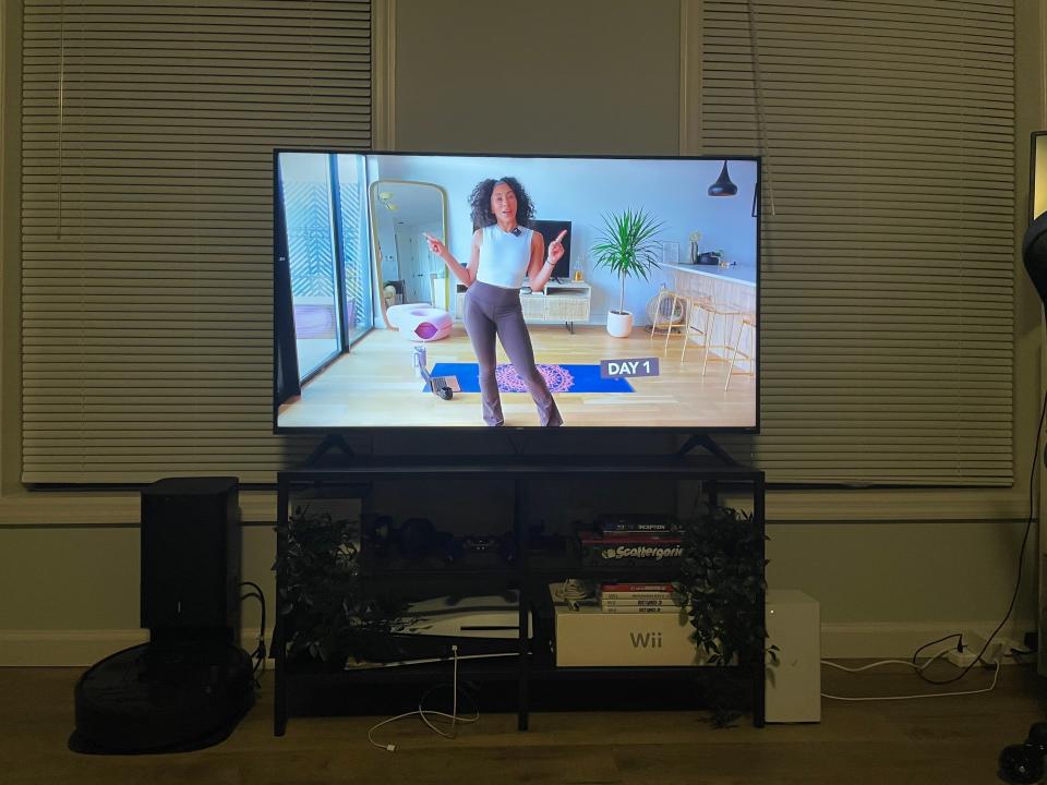 A living room with a Pilates Body Raven video on TV.