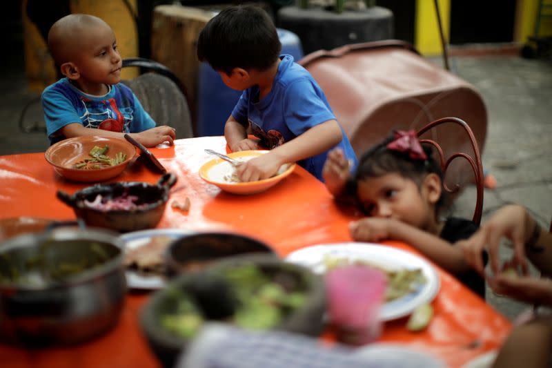 Hermes Soto speaks to his cousin as they eat lunch at a family reunion in Mexico City