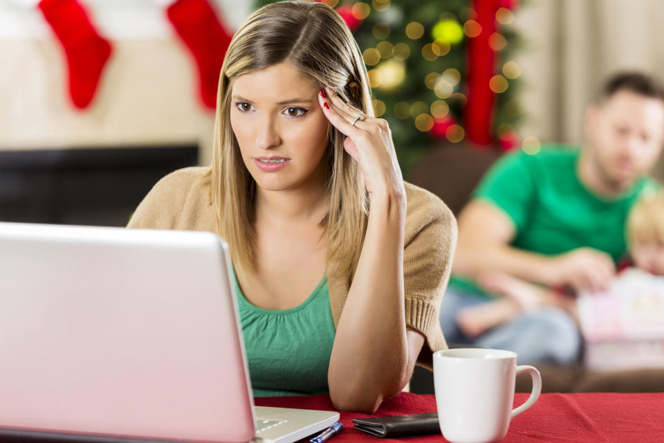 A woman looking at her computer appears to be frustrated.