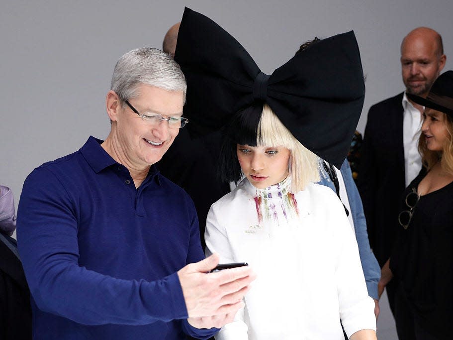 Tim Cook and Maddie Ziegler looking at a phone.