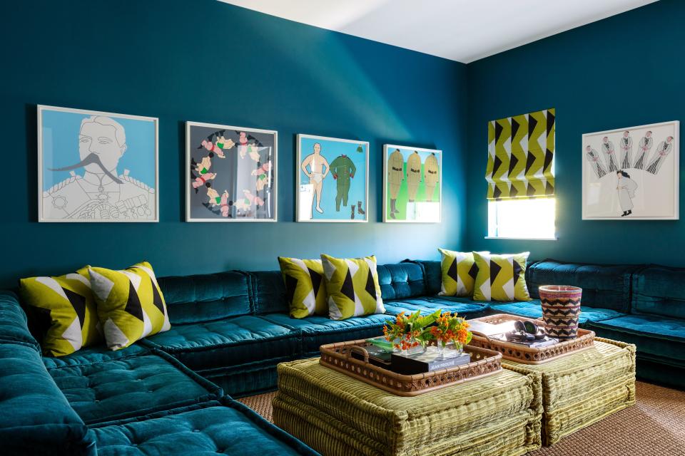 A turquoise paint by Benjamin Moore colors the lounge walls. Art by John Wesley; Roche Bobois modular sofa.