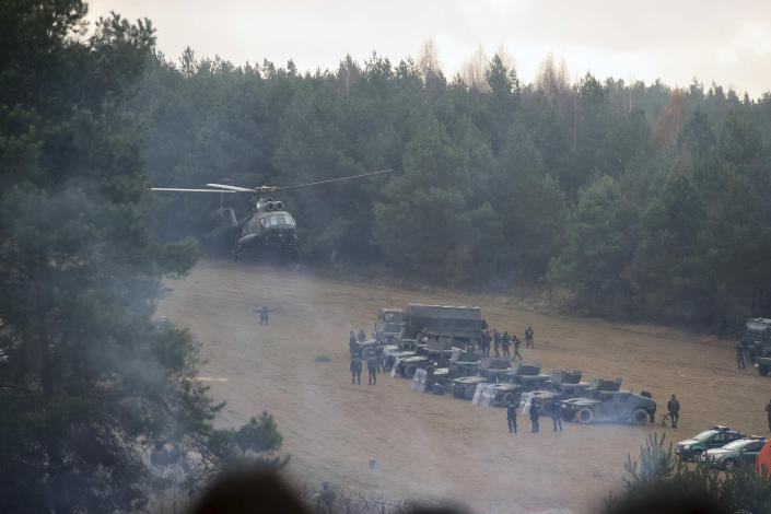 FILE - A Polish military helicopter lands next to troops near migrants gathering at the Belarus-Poland border near Grodno, Belarus, Friday, Nov. 12, 2021. For most of his 27 years as the authoritarian president of Belarus, Alexander Lukashenko has disdained democratic norms, making his country a pariah in the West and bringing him the sobriquet of “Europe’s last dictator." Now, his belligerence is directly affecting Europe. (Leonid Shcheglov/BelTA pool photo via AP, File)