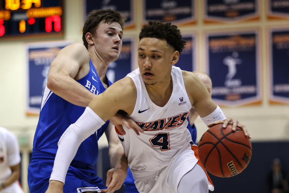 Pepperdine guard Colbey Ross, center, drives past BYU guard Connor Harding (44) during the first half of an NCAA college basketball game Saturday, Feb. 29, 2020, in Malibu, Calif. (AP Photo/Ringo H.W. Chiu)